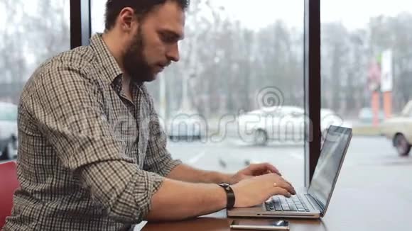 他在咖啡馆里用笔记本电脑工作静态视频的预览图