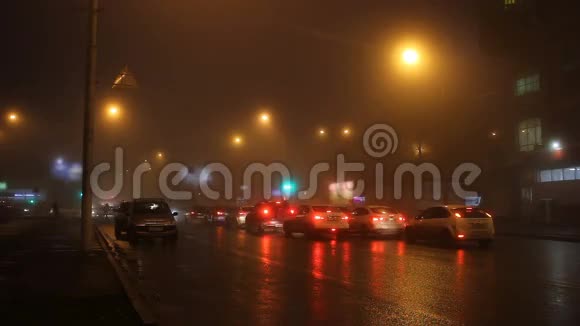 雾中的夜晚城市的灯光和道路上的汽车视频的预览图