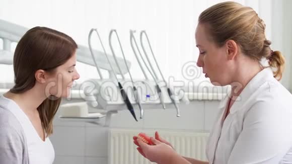 女牙医在诊所和女病人交谈工作中的女专业医生牙科检查视频的预览图
