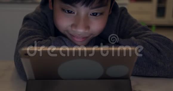 使用平板电脑关闭可爱的亚洲男孩青少年男孩玩游戏视频的预览图