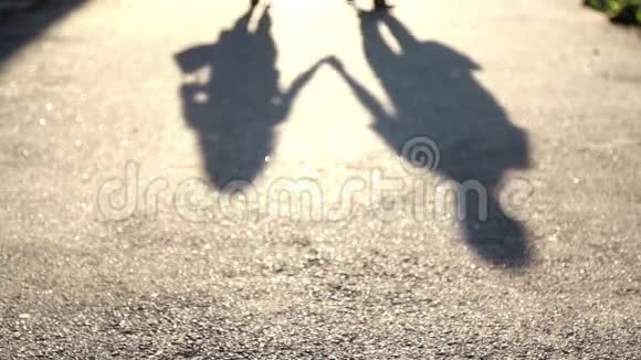 一对相爱的年轻夫妇在人行道上的影子两个人的剪影视频的预览图