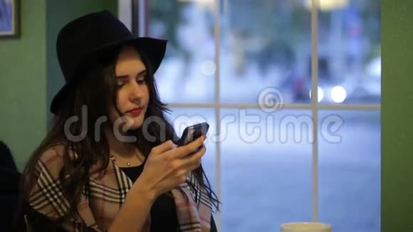 年轻的美女坐在咖啡馆里读着留言视频的预览图