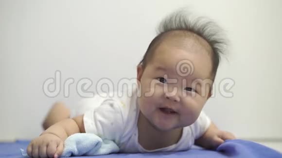 可爱的亚洲中国宝宝在肚子上滚动视频的预览图