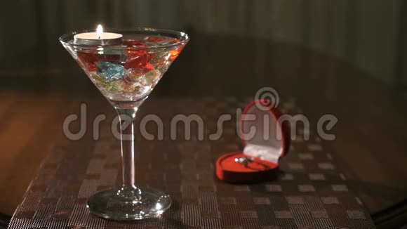 用宝石在玻璃中燃烧蜡烛订婚戒指视频的预览图