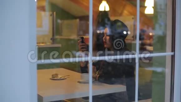 年轻的美女坐在咖啡馆里读着留言视频的预览图