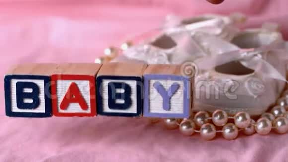 婴儿在字母块旁边婴儿在粉红色的毯子上视频的预览图