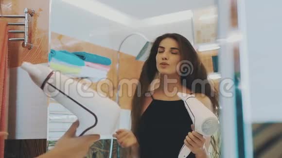 漂亮的女孩干头发由吹风机在浴室的镜子失败视频的预览图
