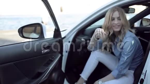 快乐的金发女郎坐在白色的车里视频的预览图