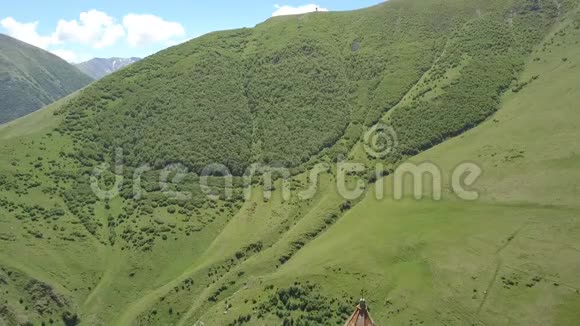 在Kazbegi山下的格鲁吉亚Gergeti村附近的GergetiTrinity教堂的空中景观视频的预览图