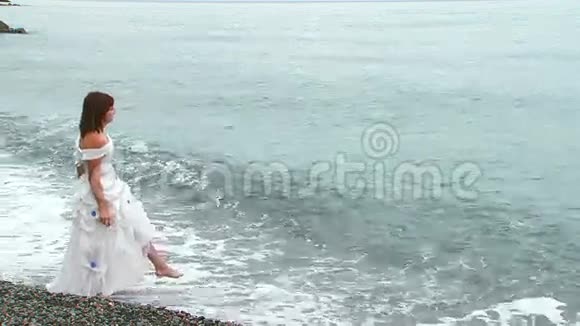 穿着白衣服走在海上的美丽女人视频的预览图