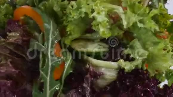 新鲜的混合蔬菜掉进沙拉碗里视频的预览图