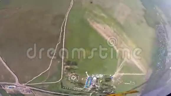 专业的跳伞运动员在绿色的田野上飞翔晴天极端风景视频的预览图