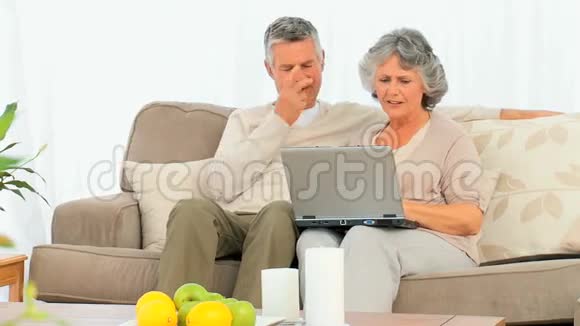 年长夫妇看着他们的笔记本电脑视频的预览图