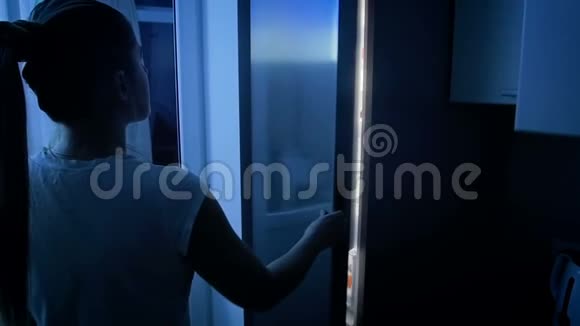 女子夜间在冰箱里寻找食物的慢动作录像视频的预览图