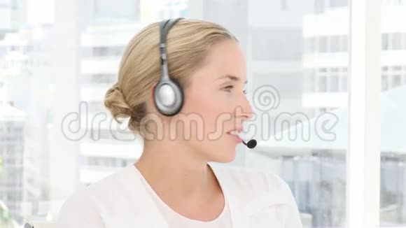 金发商务女性手持耳机视频的预览图