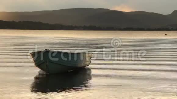 湖上夕阳下漂浮的旧船视频的预览图