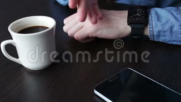 年轻商人检查手腕智能手表视频的预览图