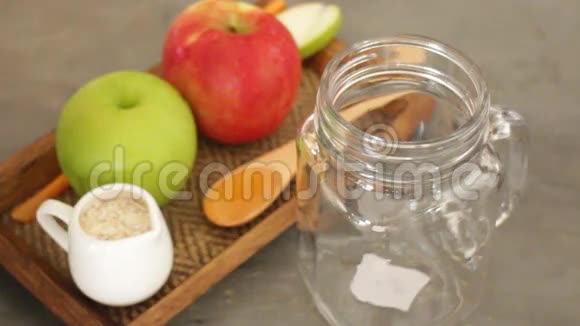 小罐子里有燕麦和蜂蜜冰沙的苹果视频的预览图