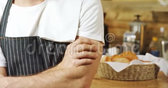 站在咖啡馆里双臂交叉的男服务员视频的预览图