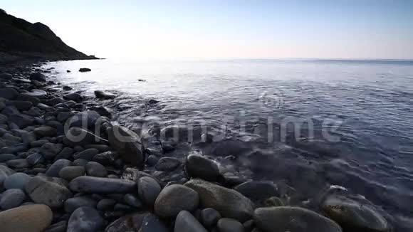平静的海浪田园诗般的海岸海滩绿松石的水和鹅卵石视频的预览图
