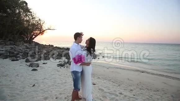 新娘新郎日出时在沙滩拥抱视频的预览图