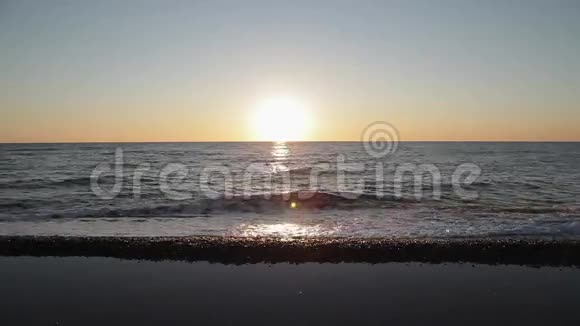 海滩上美丽的日落令人惊叹的色彩一缕阳光透过海面上的云彩闪闪发光视频的预览图