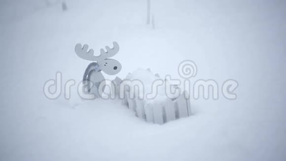木制玩具驼鹿和雪地里的小栅栏视频的预览图