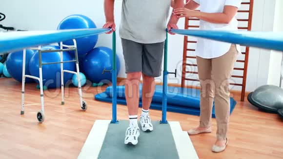 物理治疗师帮助病人双杠行走视频的预览图