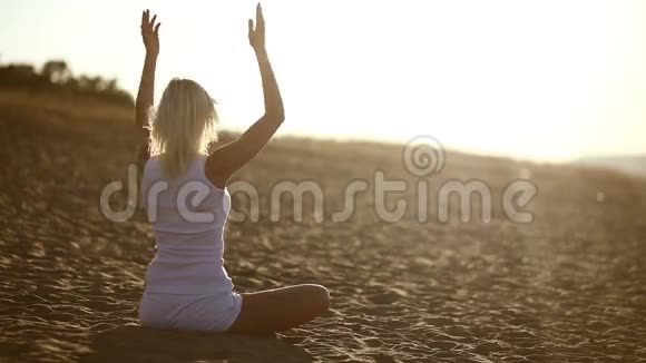 白衣女子坐在沙滩上沉思健康视频的预览图