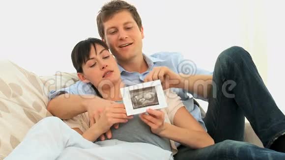 一对夫妇看着他们未来孩子的扫描视频的预览图