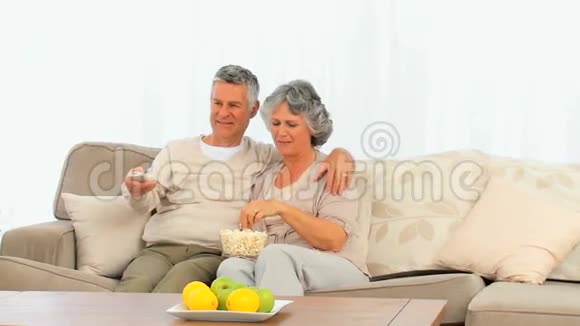 成熟的夫妻在电视前吃爆米花视频的预览图