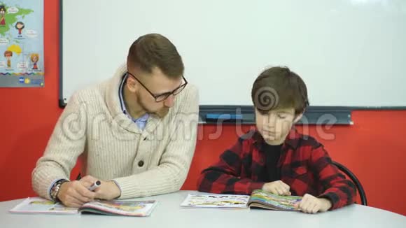 男生在教室里和老师一起学习视频的预览图