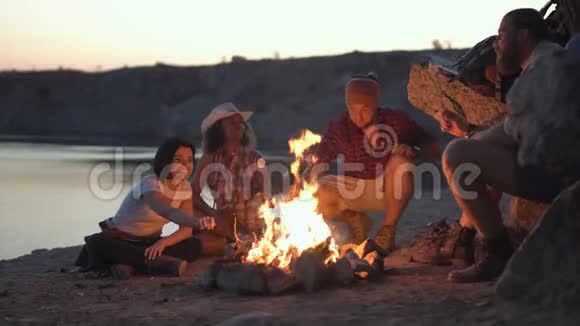 快乐的朋友在篝火旁放松视频的预览图
