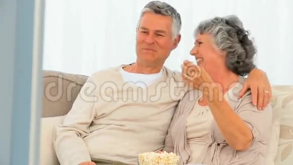 成熟的夫妻在电视前吃爆米花视频的预览图