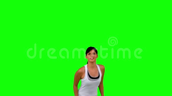 穿着运动服的女人在绿色屏幕上跳跃视频的预览图