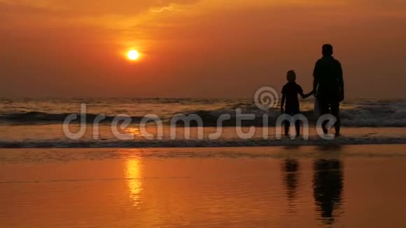 快乐的一家人玩得开心在海滩上看日落视频的预览图