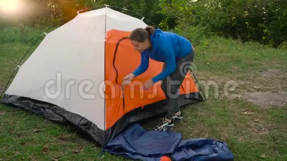 日落时分女人正在森林里搭一个旅游帐篷视频的预览图