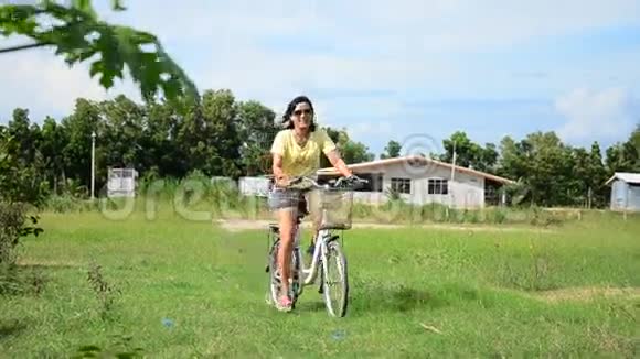 泰国妇女在花园里骑自行车视频的预览图
