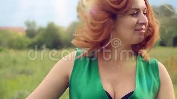 幸福的微笑红发女人穿着绿色的长发视频的预览图