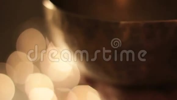 拿着木槌对着藏语唱碗的喉咙散焦点燃蜡烛视频的预览图