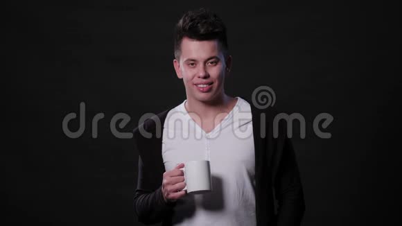 一个男人拿着杯子在黑色背景下视频的预览图