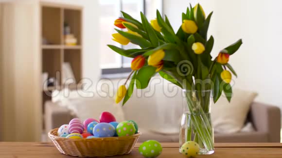 篮子里的彩色复活节彩蛋和家里的鲜花视频的预览图
