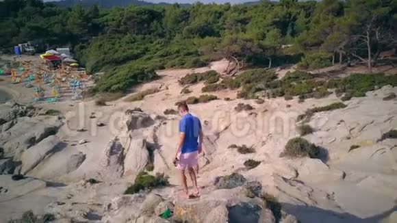 人在岩石海滩空中射击视频的预览图