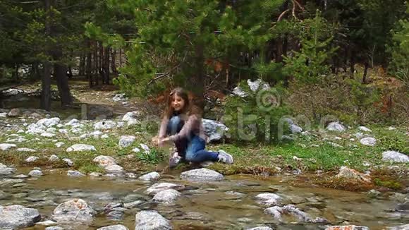 快乐的女孩从小溪里喷出水笑了视频的预览图