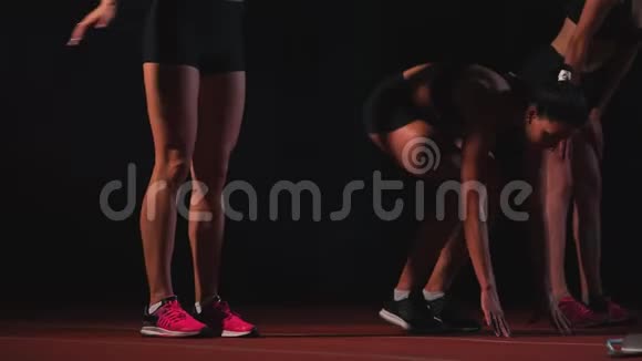 三个穿黑色衣服的女孩在比赛开始的垫子上开始比赛视频的预览图