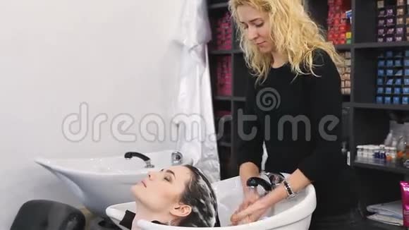 女孩在美发沙龙洗头视频的预览图