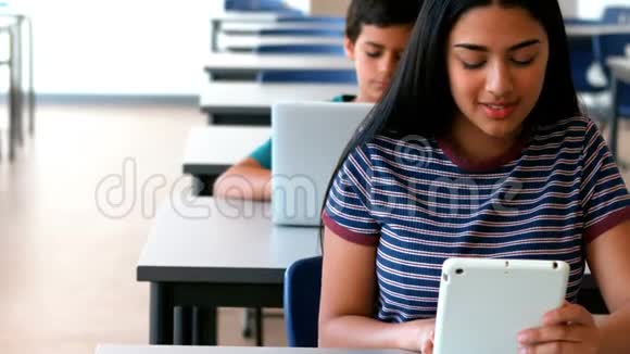 女生和男生在教室学习时使用笔记本电脑和数码平板电脑视频的预览图