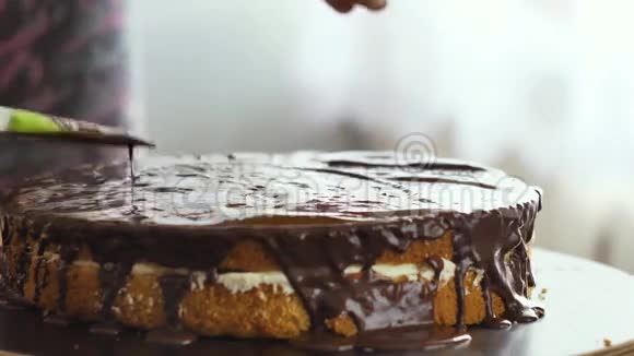 女性手把巧克力奶油倒在蛋糕上开始散开视频的预览图
