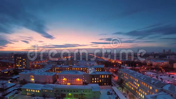 冬天的夜晚城市从屋顶时间推移到冬季的傍晚城市景色城镇和屋顶的全景视频的预览图