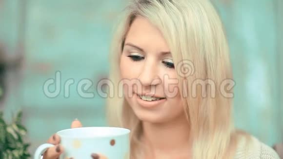 美丽的金发女郎喝茶视频的预览图